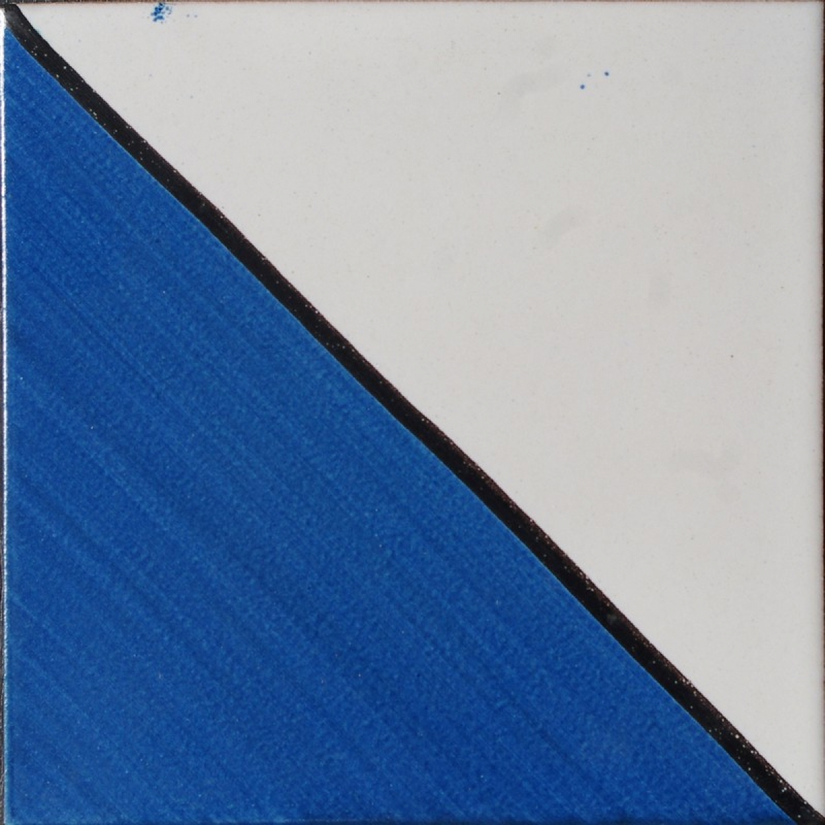 Maiolica decorata divisa in diagonale blu e bianca con riga